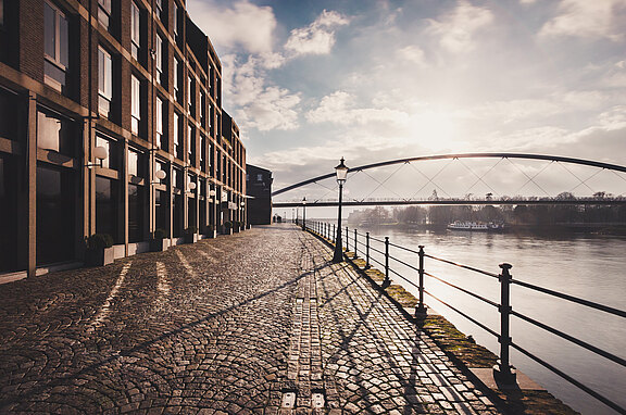 Ein Bild mit Wasser und Brücke im Hintergrund.